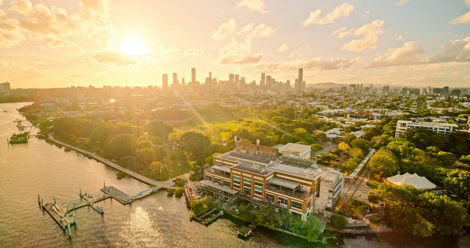 Aerial view of the Brisbane Powerhouse on the riverbank at golden hour